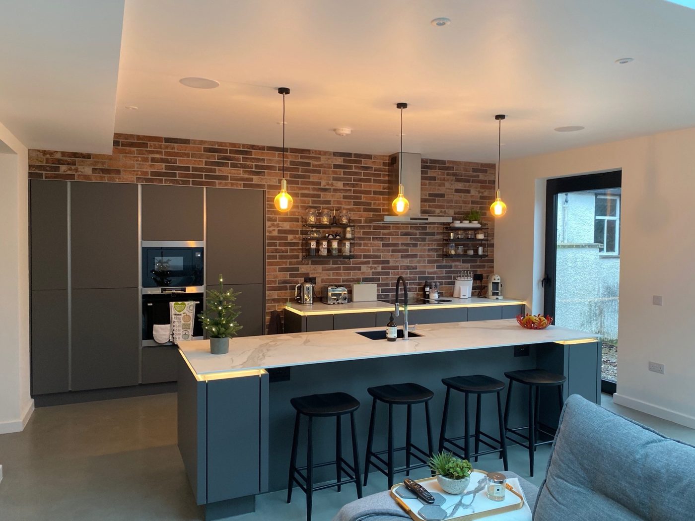 Graphite kitchen with island, marble-effect worktop and exposed brick wall