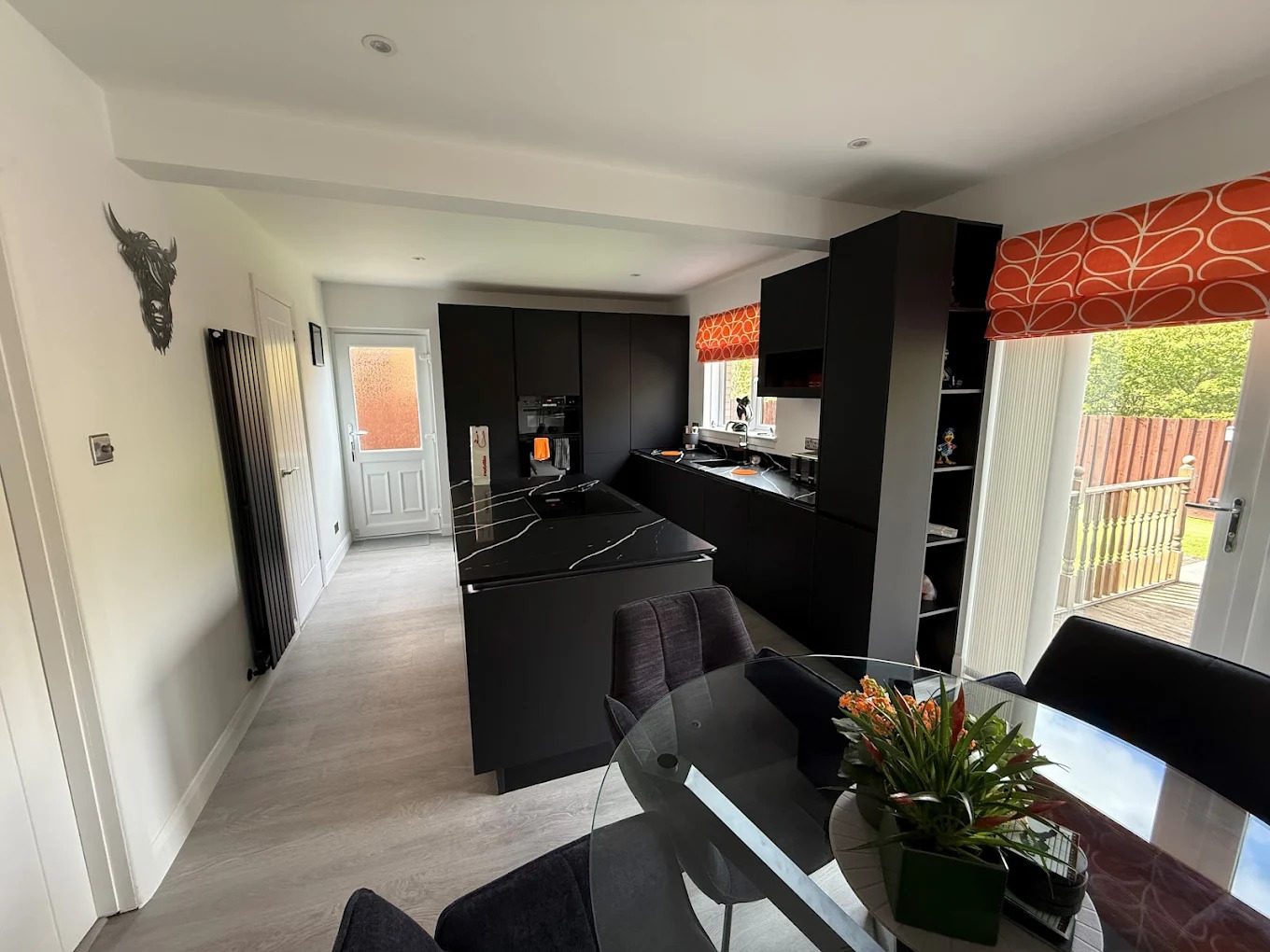 Matt black open-plan kitchen with island and black marble worktop