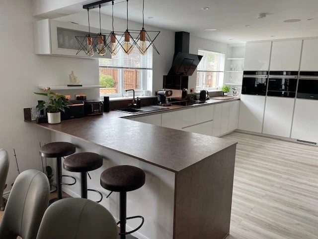 White kitchen with a peninsula breakfast bar and integrated appliances